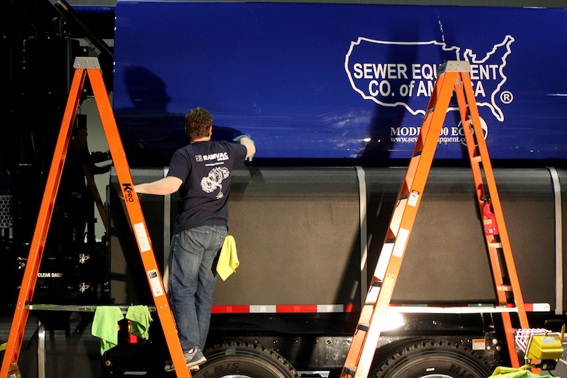 Matt Henthorn of Sewer Equipment of American polishes the side of a truck in their booth on Tuesday during WWETT Show setup.