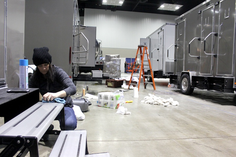 Nicolle Platz, with the company A Restroom Trailer, Inc. (ART), cleans the stairs of a restroom trailer during WWETT Show setup on Tuesday.