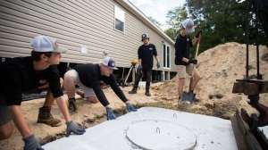 Young workers place cement septic tank